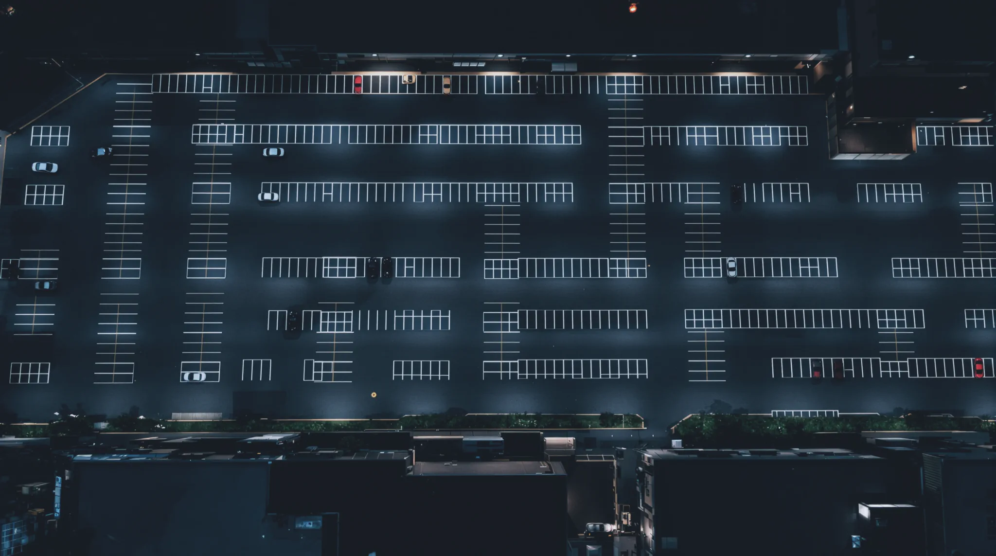 A retail parking lot at night, rows of cool white light poles.