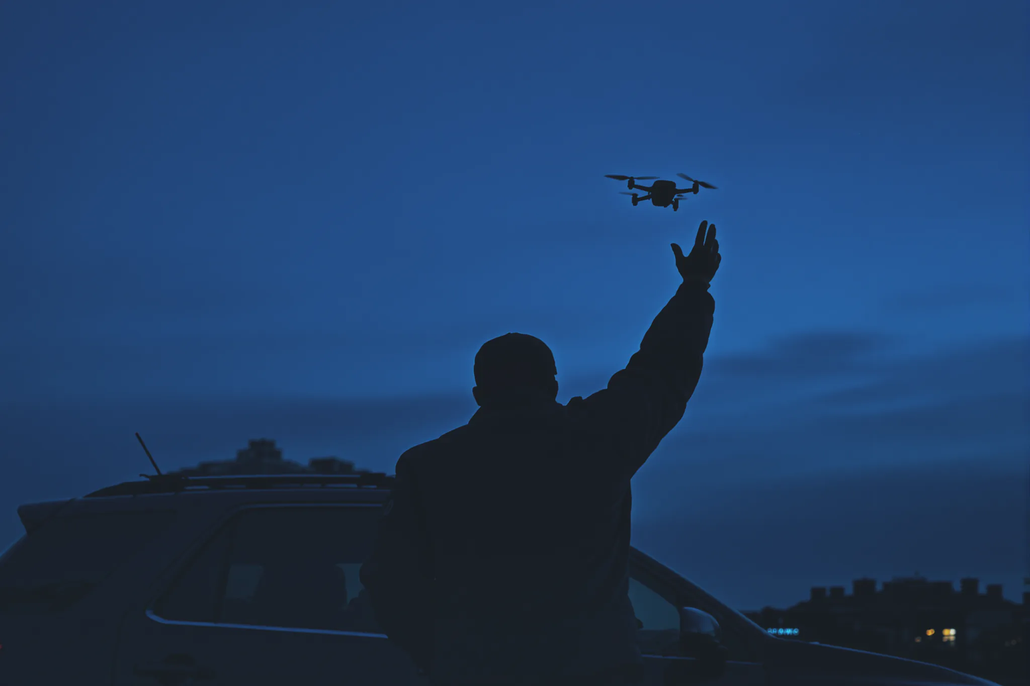 A Sentinel responder launching a quadcopter drone at night.